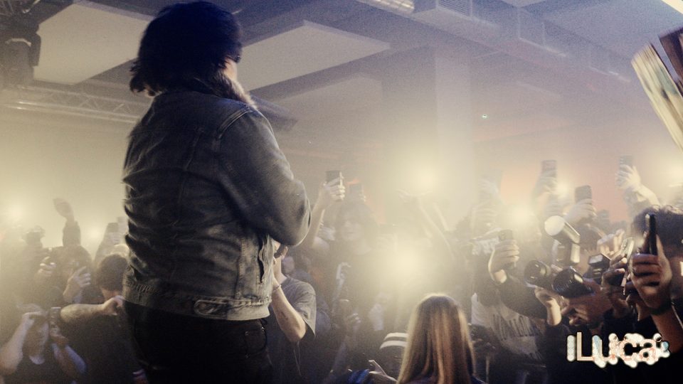 2Slimey with his back to the camera facing a crowd of phone lights