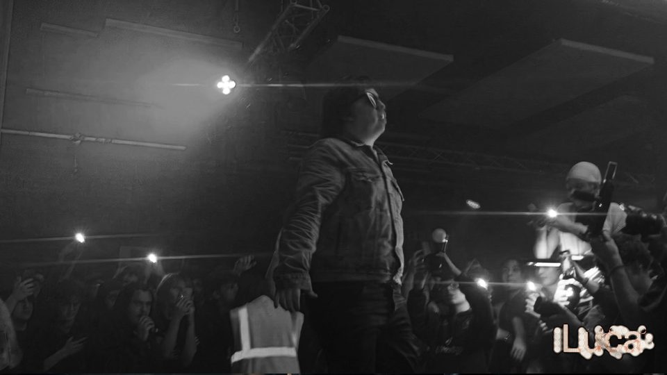 Black-and-white frame of 2Slimey above the crowd