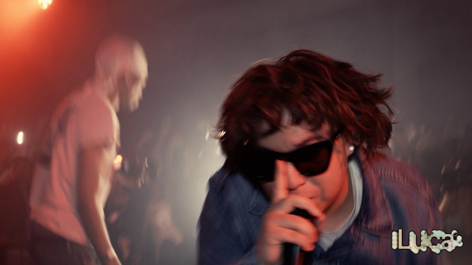 2Slimey in sunglasses, finger to his lips, under red light