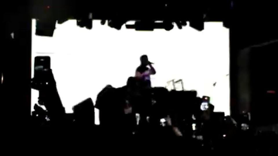 EsDeeKid silhouetted against a white stage screen