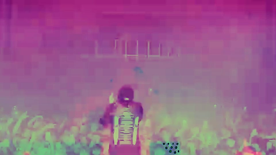 EsDeeKid above a crowd in a magenta-washed frame